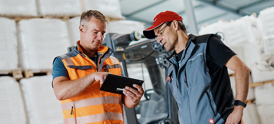Lagermitarbeiter mit Tablett und Gabelstapler
